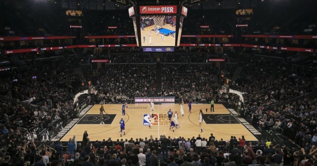 A basketball game on a 30 feet wide basketball court.