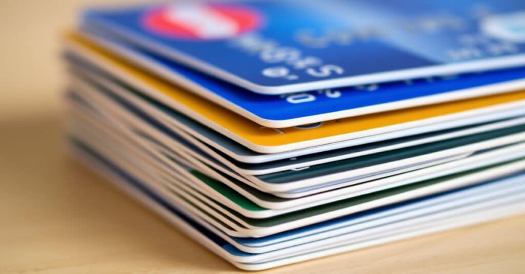 A stack of credit cards laid flat on the wooden table.