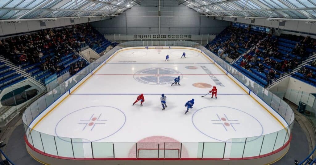 An ice hockey rink, measuring 80 feet in width, with players in action.