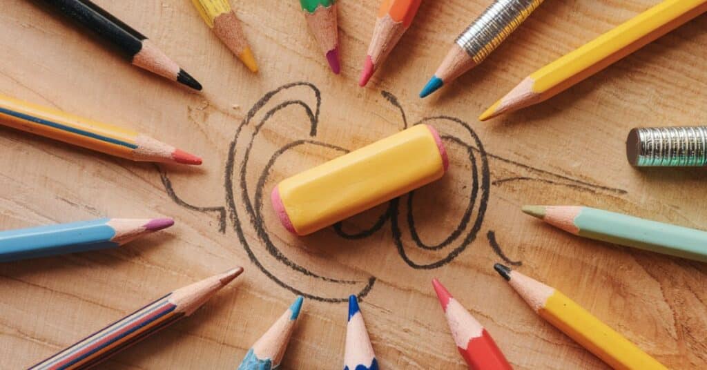 A Kneaded eraser is surrounded by different colours of pencils.