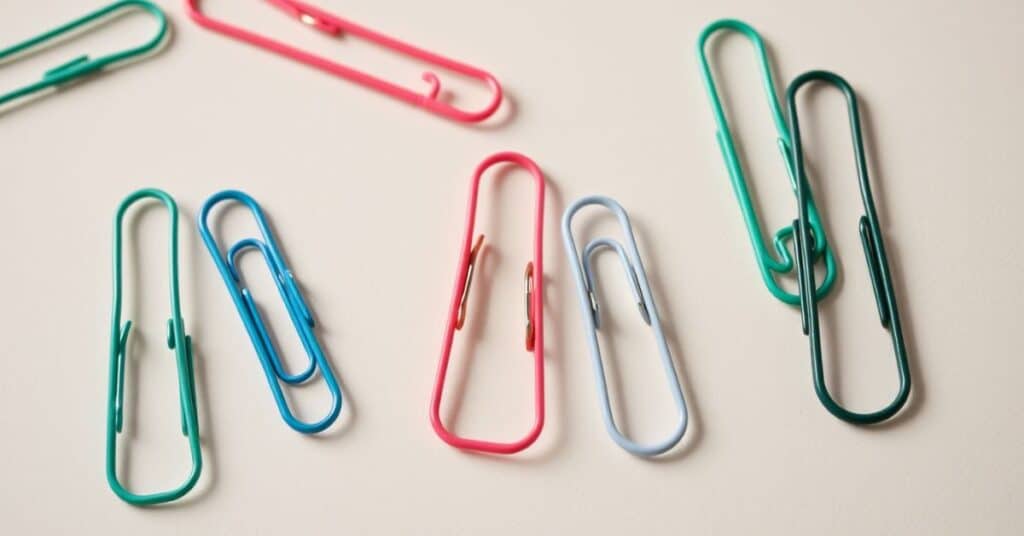 Different colours and sizes of paper clips are placed next to each other.