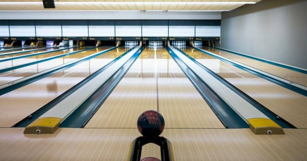 A regulation bowling lane with the foul line, pins and ball at the start.