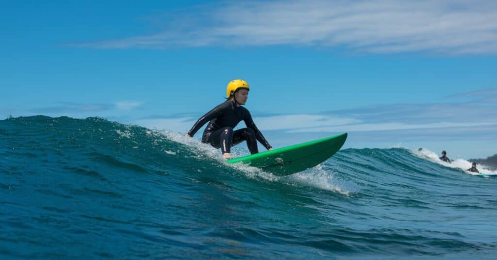 A man is surfing in the ocean on the 3 feet surfboard.