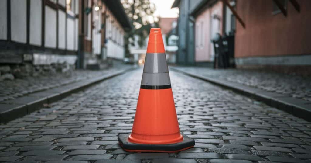 A traffic cone is placed in the middle of the alley.