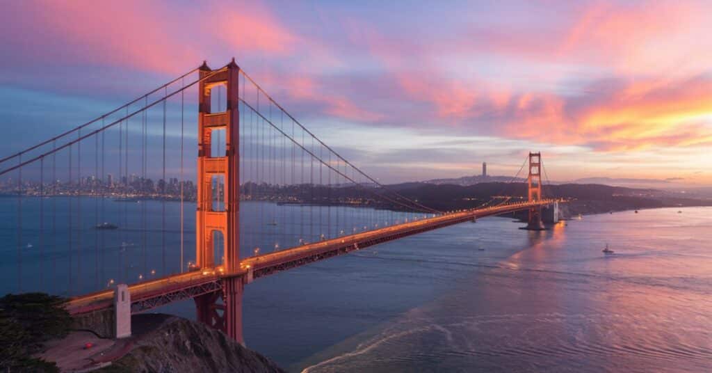 A sunset view of the 500 feet long Golden Gate Bridge with the bay in the foreground.