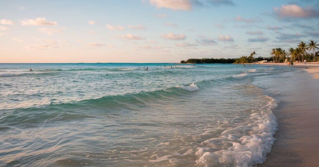 A photo of Siesta Key Beach during the day. The photo is taken from the shoreline, looking out at the clear blue water and white sand.