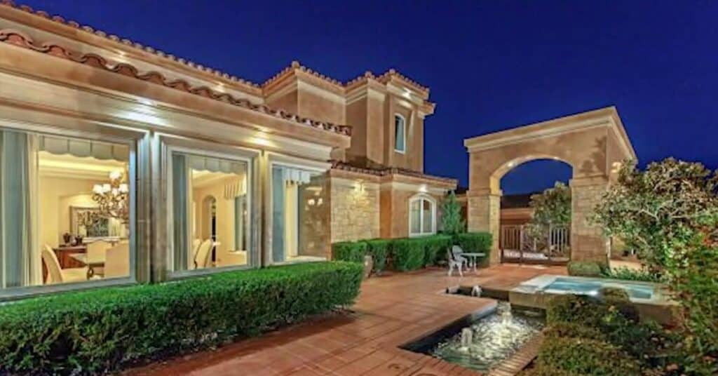 A picture of Mike Tyson second mansion. It is brown themed mansion, with a swimming pool outside the mansion.