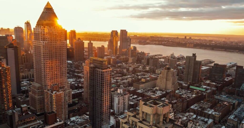 Ariel view of New York City at sun rise. Various skycrappers are shown in the photo.